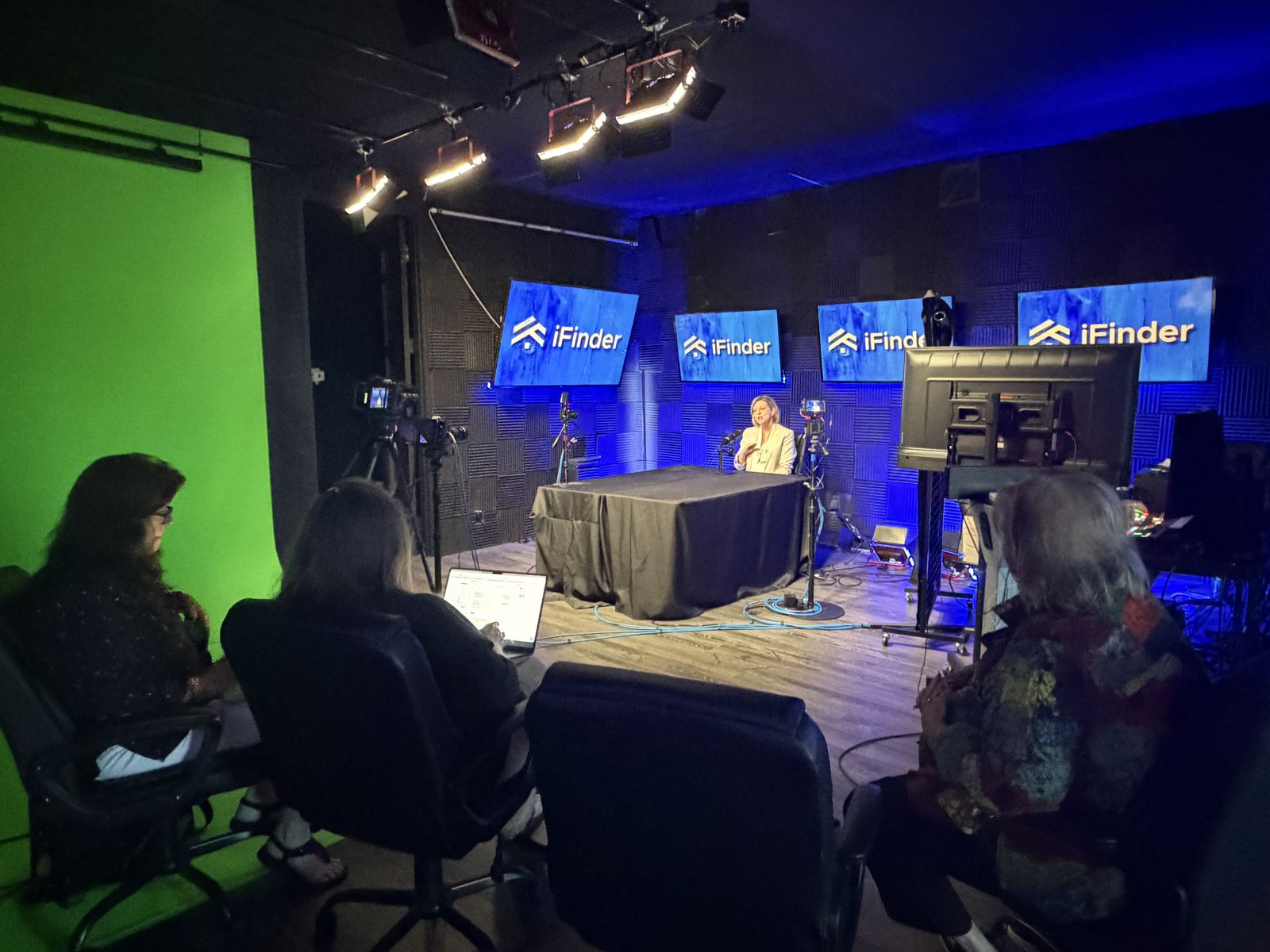 Wide view of a group recording day on the blue set at studioUSA East in Plano, with the green screen at left