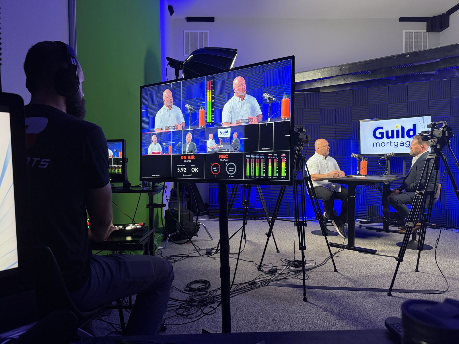 Producer at the control desk with a multi-view monitor during a three-person session at studioUSA West