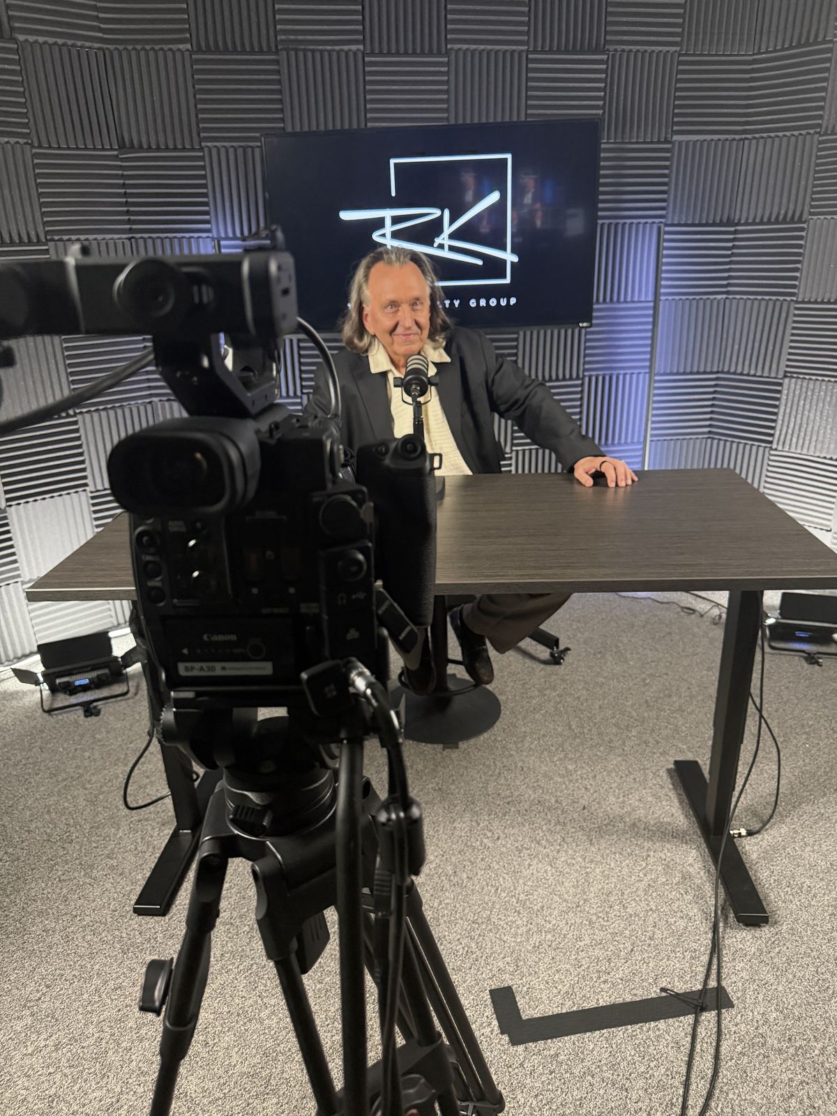 Studio camera in the foreground framing a guest at the desk at studioUSA West